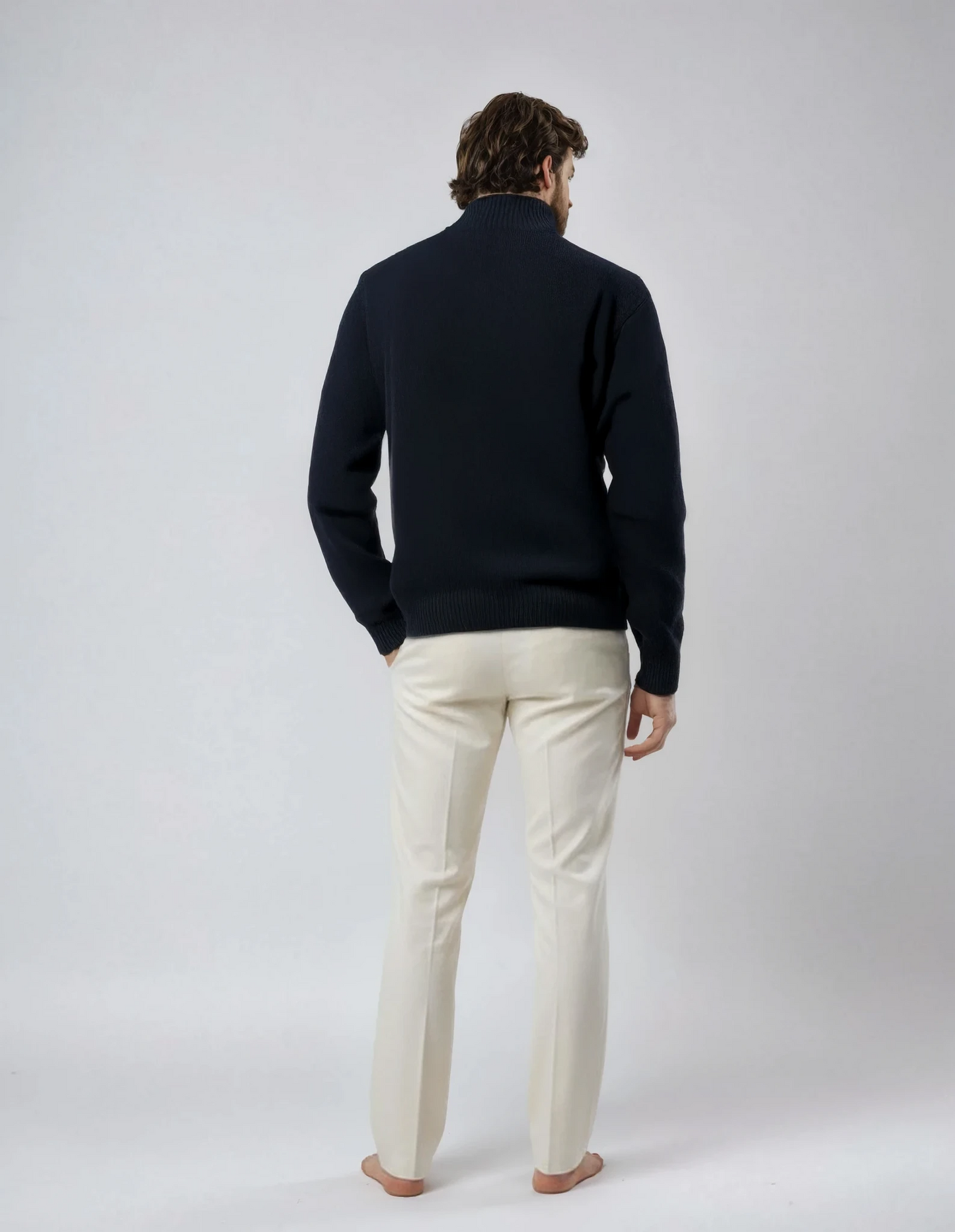 Rear view of a male model wearing a casual full-zip wool cardigan in navy blue