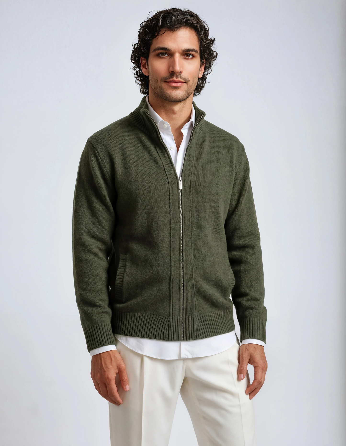 Front view of a man wearing an olive green zip-up knit cardigan over a white collared shirt and cream trousers, featuring ribbed cuffs and hem.