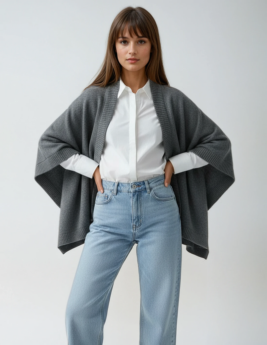 Dark grey wool cape worn over denim jeans