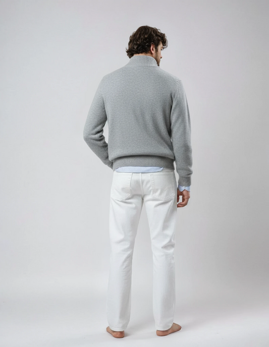 Rear view of a barefoot male model wearing a light gray wool jacket with front zipper and pockets, standing against a neutral background.