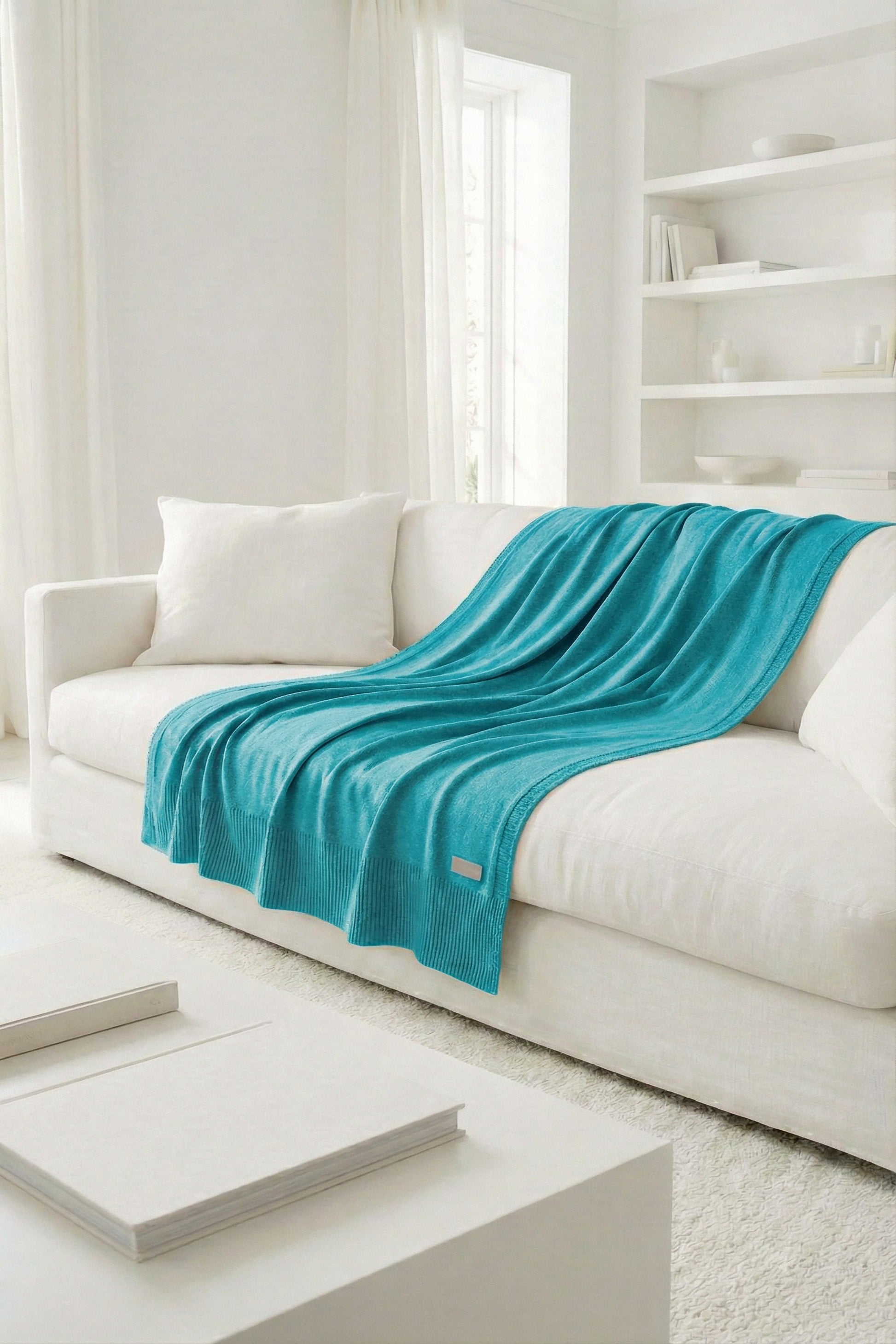 Vibrant ocean teal cotton knit throw, highlighting the contrast between the flat-knit center and ribbed trim.