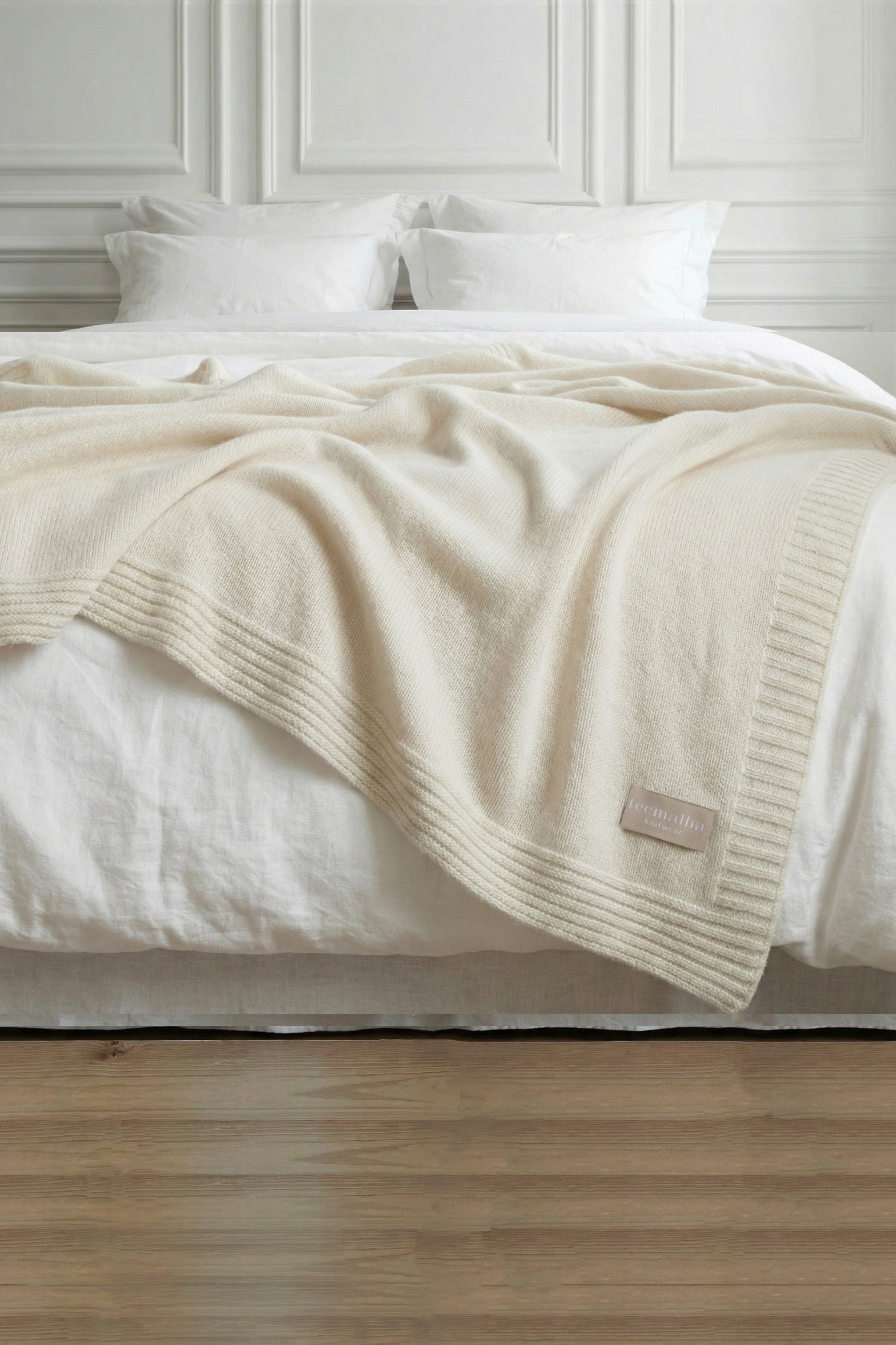 Tecmalha pearl white lambswool blanket featuring a plain knit pattern and a ribbed border. Made in Portugal