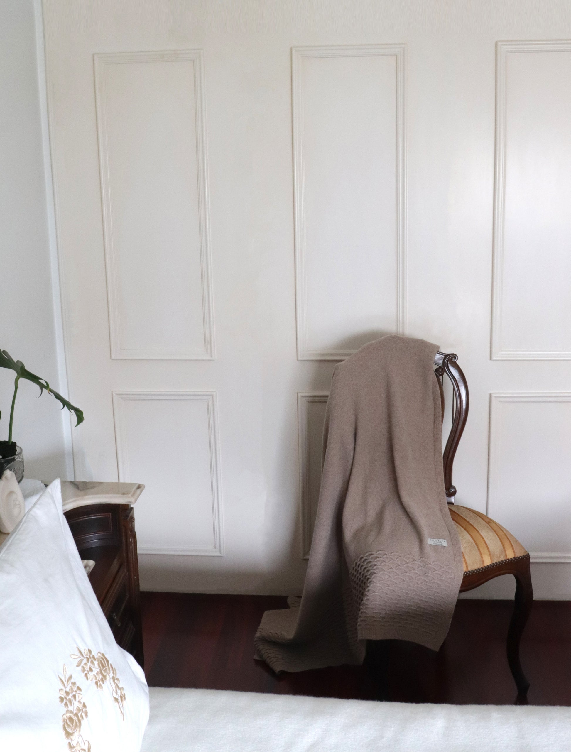 Beige wool blanket with a raised wave pattern detail on the edges.